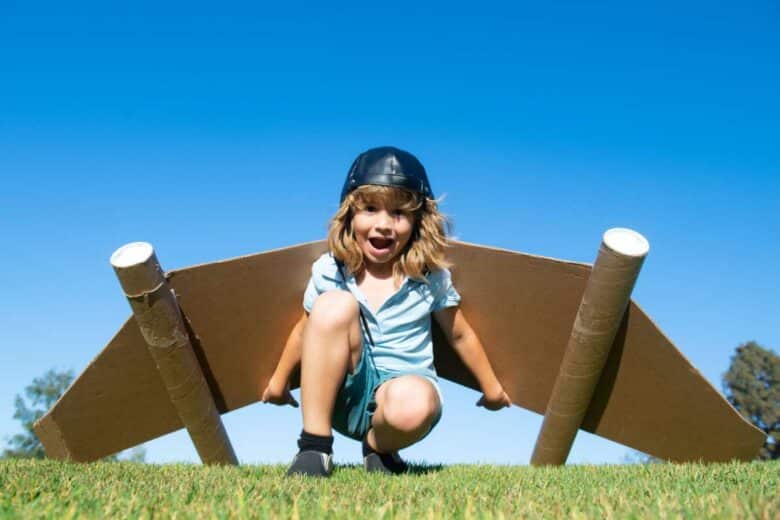 Un jeune garçon avec des ailes en carton sur le dos.