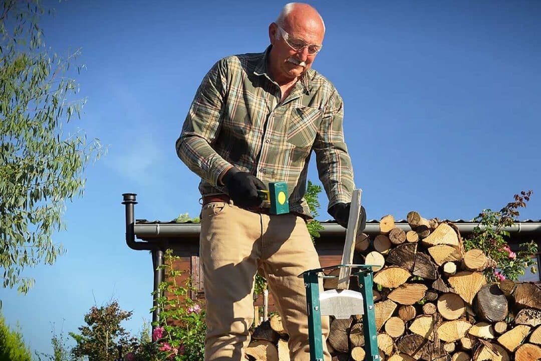 Un homme fend des bûches.