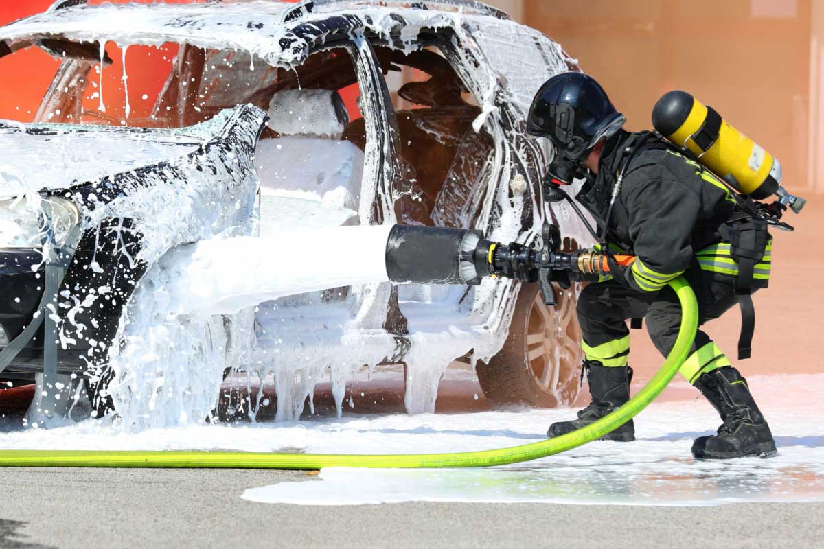 Extinction d'un incendie de véhicule par un pompier.
