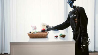 Le robot humanoïde range des objets sur une table.