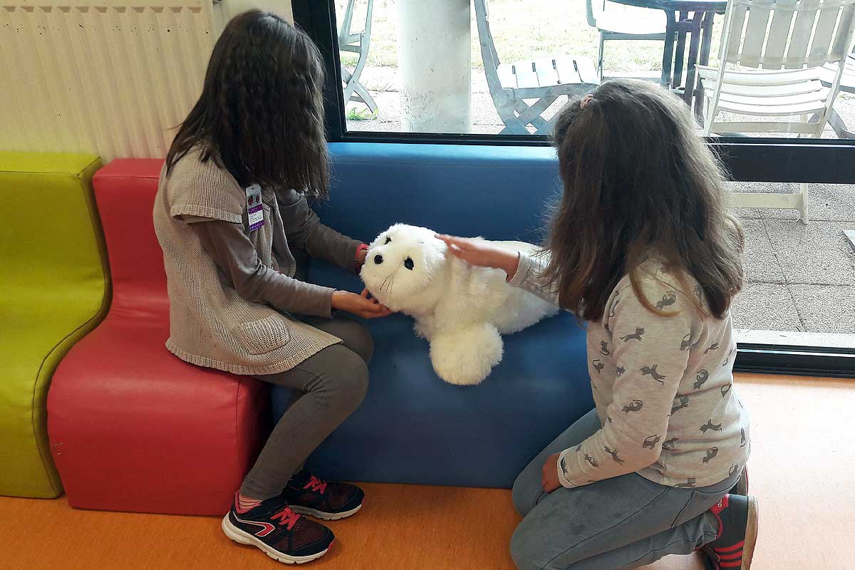 Deux jeunes filles et un phoque Paro.