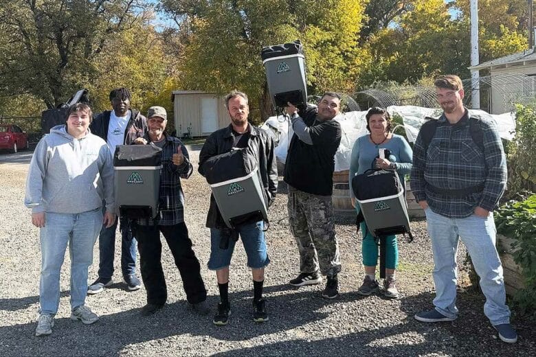 Le fondateur de l'association et des sans-abri avec des sacs à dos solaires.