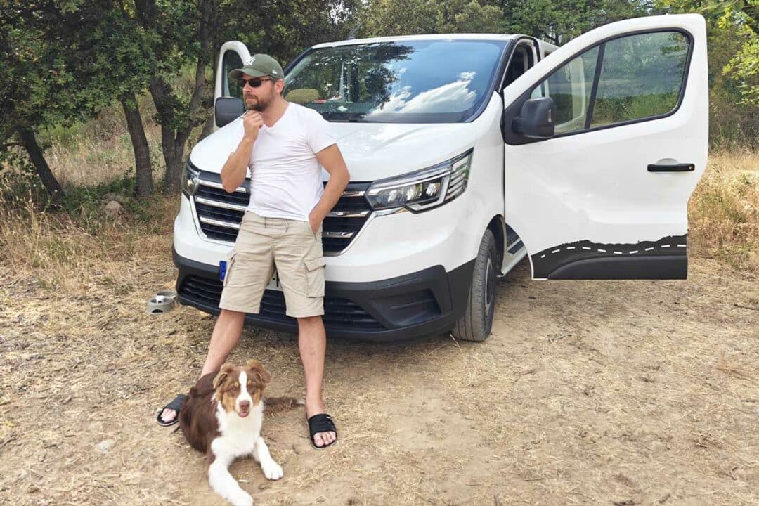 Un homme devant son van aménagé.