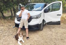 Un homme devant son van aménagé.