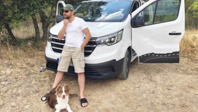 Un homme devant son van aménagé.