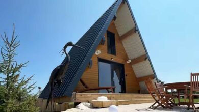 Une maison en A avec une sculpture à l'entrée.