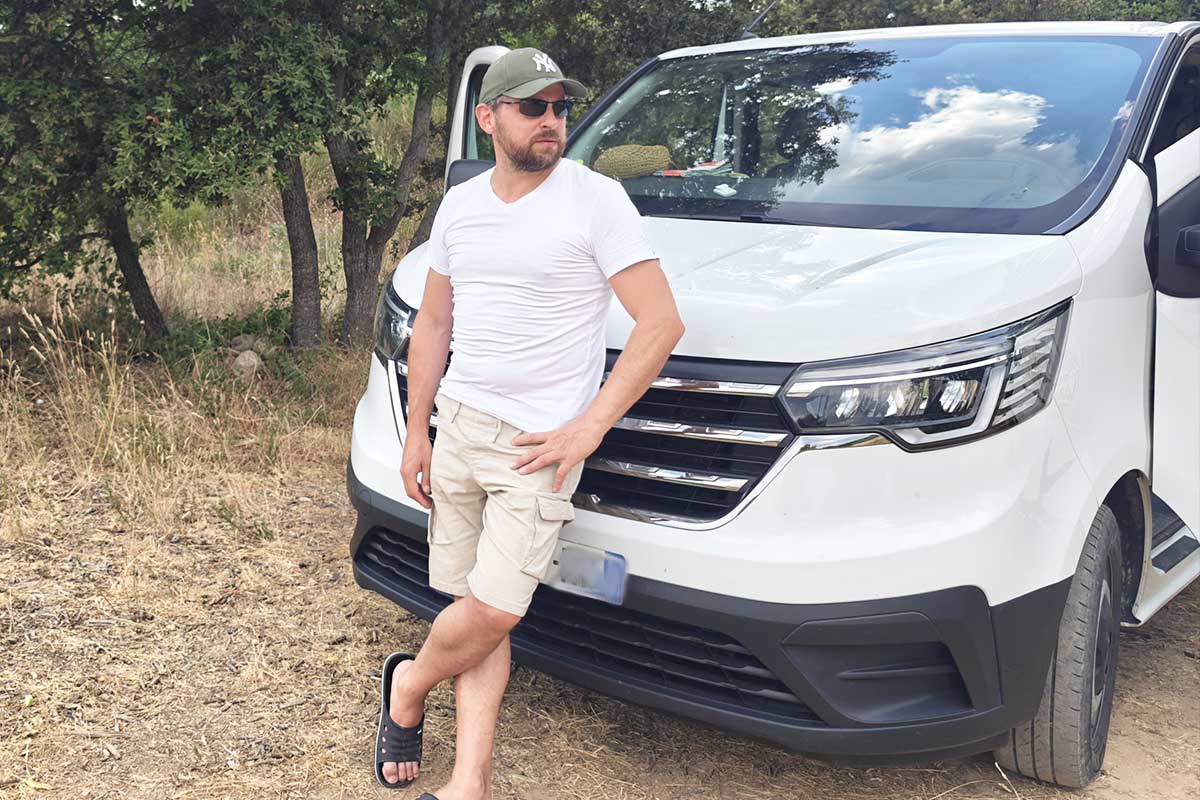 Un homme devant un Renault Trafic.