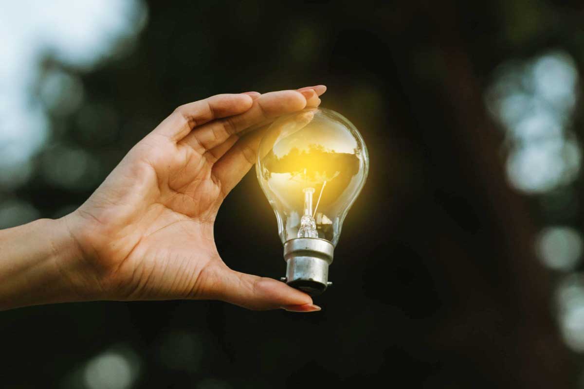 Une femme tient une ampoule.