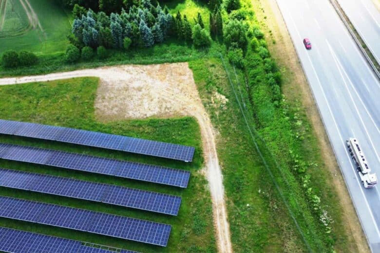 Des panneaux solaires sur un terrain proche d'une route.
