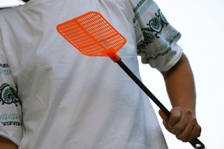 Un homme avec une tapette dans les mains.