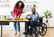 Un couple dont l'homme est en fauteuil roulant cuisine.