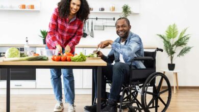 Un couple dont l'homme est en fauteuil roulant cuisine.