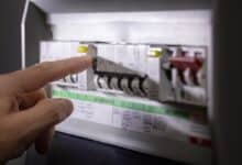 Une personne manipule son tableau électrique.