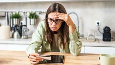 Une femme hésite à donner son code bancaire en ligne.