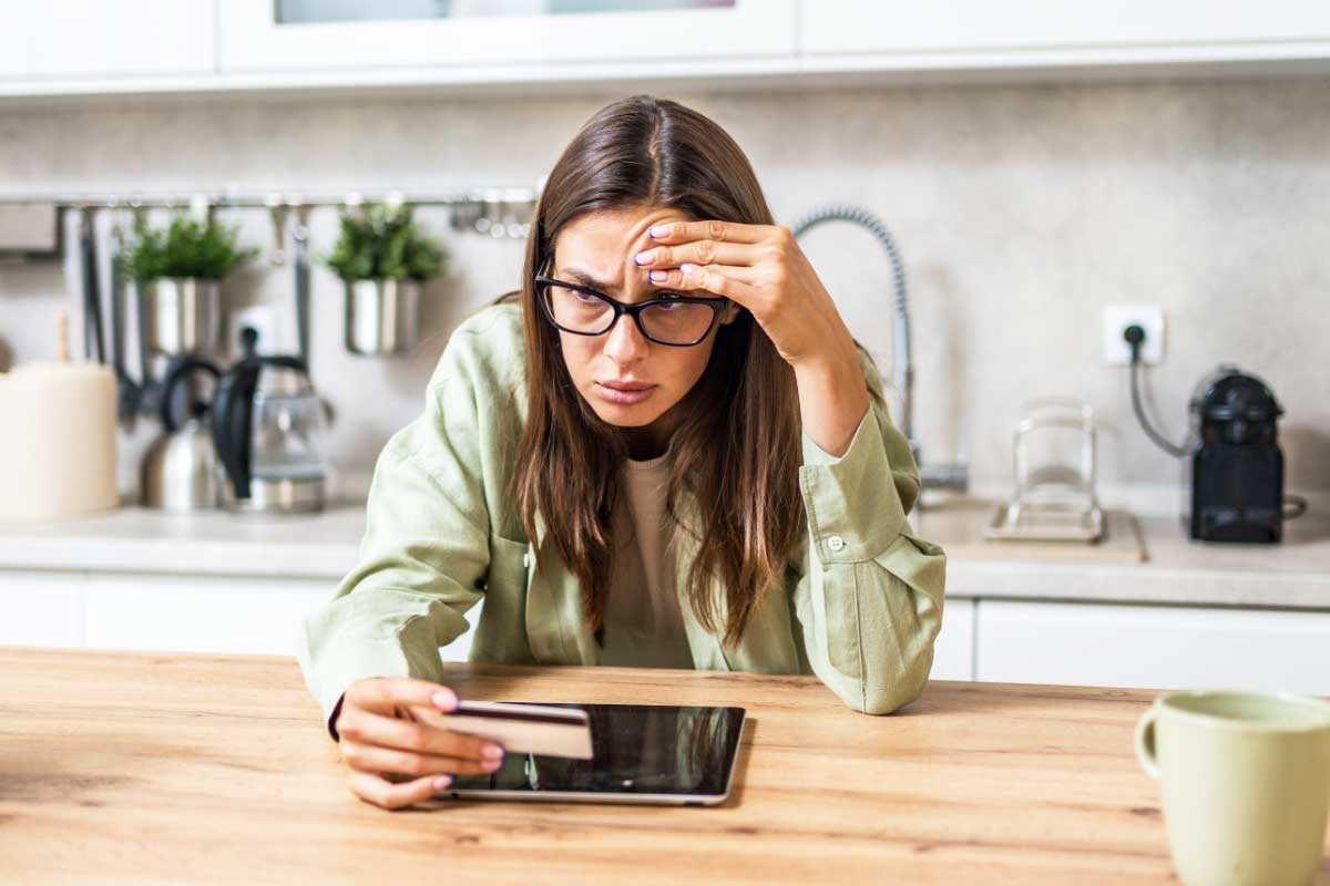 Une femme hésite à donner son code bancaire en ligne.