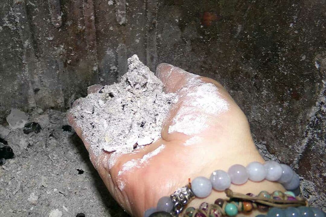 Une main tenant des cendres de bois.