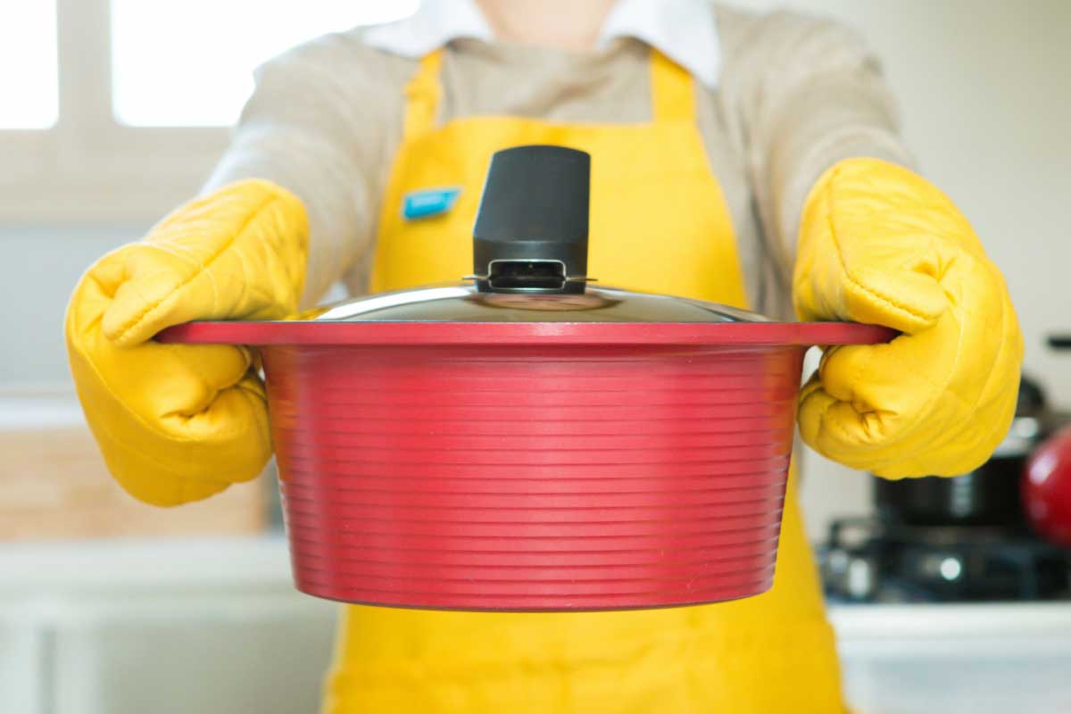 Une personne tient une marmite dans les mains.