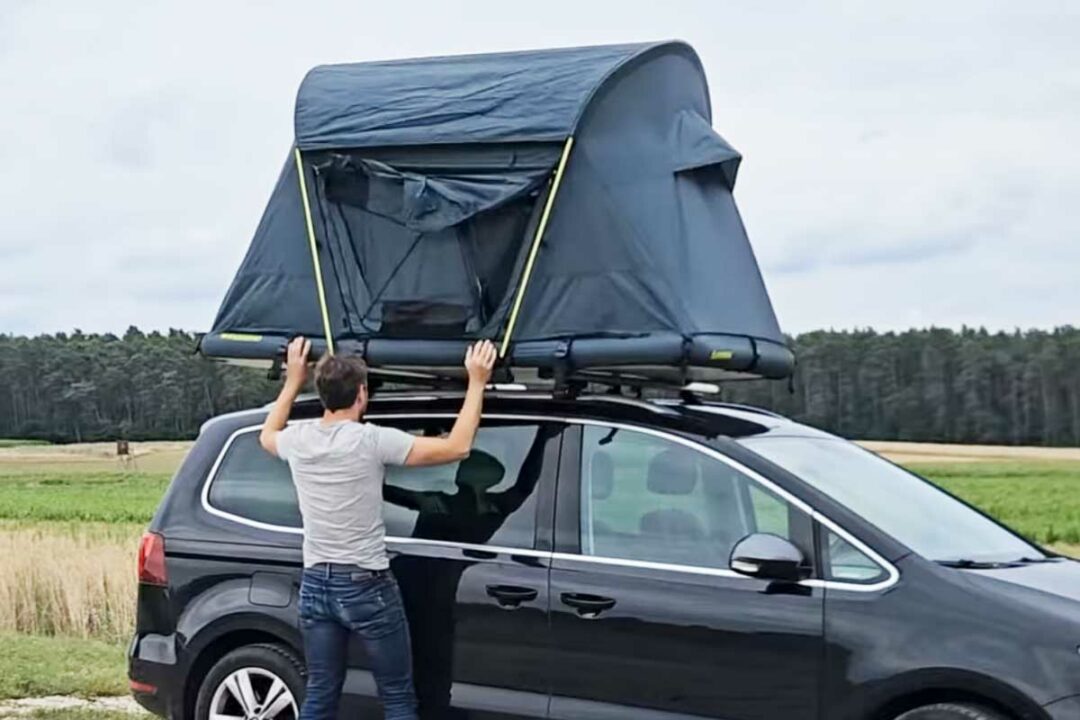 Un homme installe une tente de toit Groenberg.