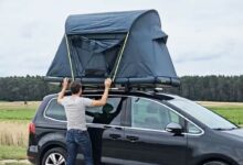 Un homme installe une tente de toit Groenberg.