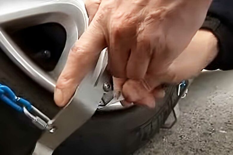 Installation de chaines à neige sur un véhicule.
