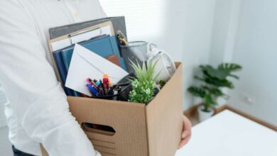 Une personne avec ses affaires quitte ton poste.