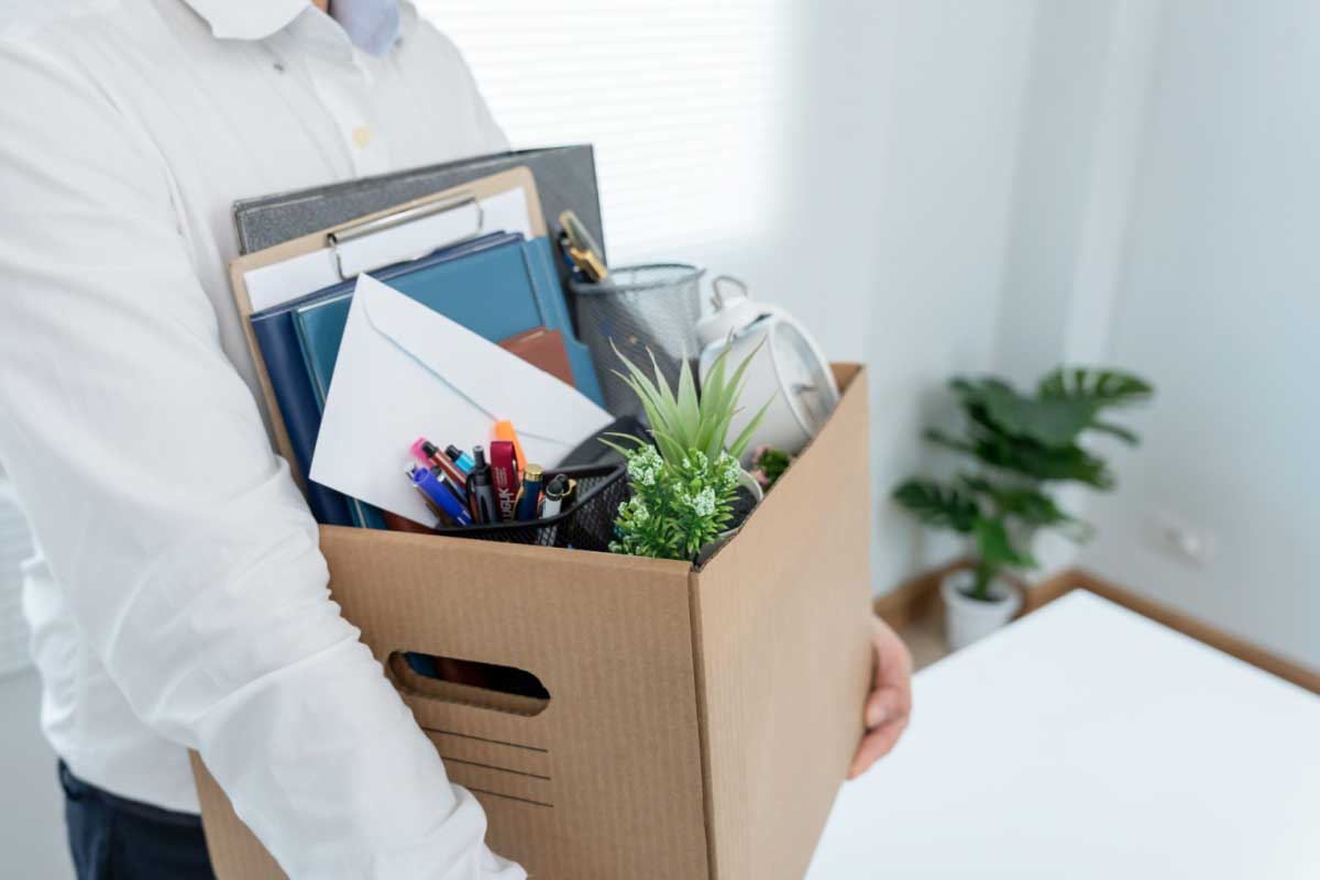 Une personne avec ses affaires quitte ton poste.