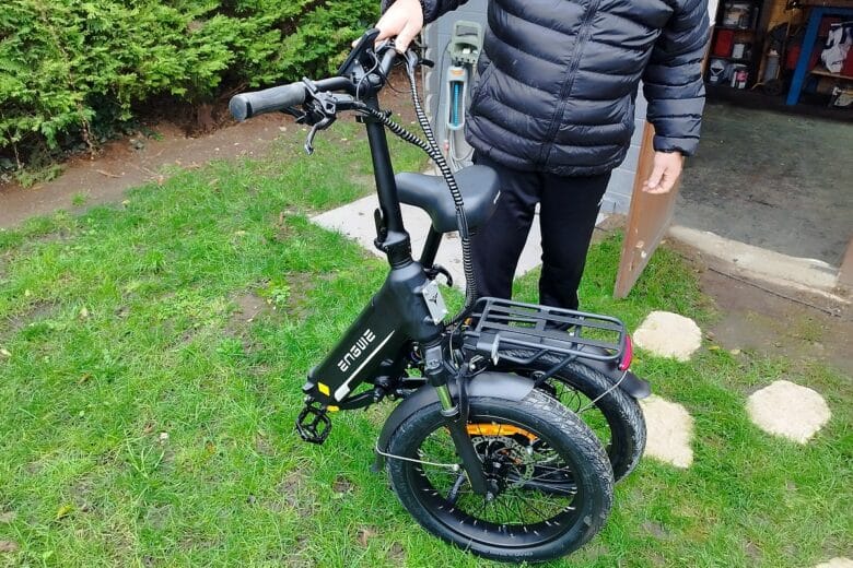 Le ENGWE L20 3.0 Boost est entièrement plié et tenu par mon mari, démontrant sa compacité.